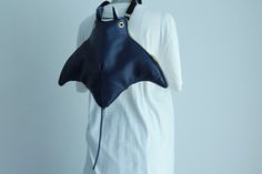 a woman's white shirt with a blue bag on her shoulder and the top half of it being held up by a mannequin