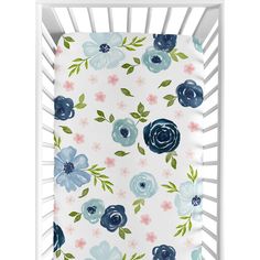 a white crib with blue and pink flowers on it