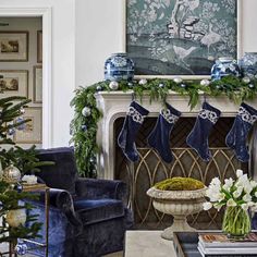 a living room decorated for christmas with blue and white decorations on the fireplace mantel