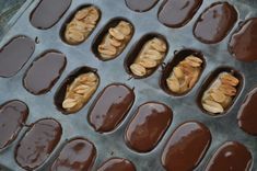 chocolates with nuts in them sitting on a baking sheet