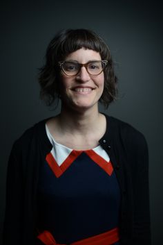 a woman with glasses smiling for the camera