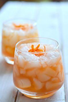 two glasses filled with orange bourbon smash