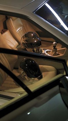 the interior of a car with leather seats and helmets in it's center console