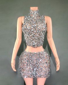 a mannequin wearing a silver dress with lots of sequins on it