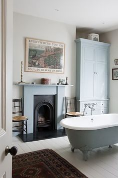 a bathroom with a fireplace in the corner and a bathtub on the floor next to it