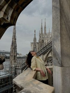 a woman standing on top of a stone building