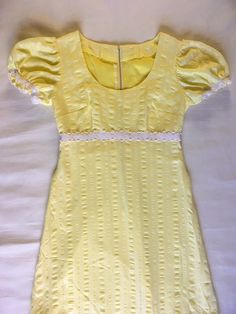 "This lovely 1970's vintage prairie dress is in excellent condition with no tears or stains. ------- Measurements: ------- * 29\" fitted waist * 34\" pleated bust * 55\" full length (ie: back collar to bottom hem) * 19.5\" metal zipper (in back) ------- Details: ------- * Handmade with full inside lining * Yellow fabric with textured details  * Lace detail at the empire waist * Lace sleeve edges * Puffed sleeves" 1970s Prairie Fashion, Fitted Vintage Dress With Puff Sleeves For Summer, Spring Vintage Dress With Fitted Bodice And Empire Waist, Fitted Summer Prairie Dress, Fitted Short Sleeve Prairie Dress For Daywear, Fitted Prairie Dress For Summer Daywear, Fitted Summer Prairie Dress For Daywear, Spring Fitted Vintage Dress With Lining, 1970s Empire Waist Fitted Dress