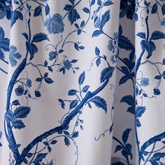 a blue and white curtain with flowers on it