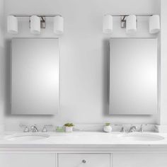 two white sinks and mirrors in a bathroom