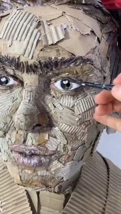 a woman is making a paper mache face