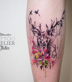 an artistic tattoo on the leg of a woman with flowers and deer's head