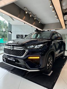 a black suv is on display in a showroom with white walls and flooring