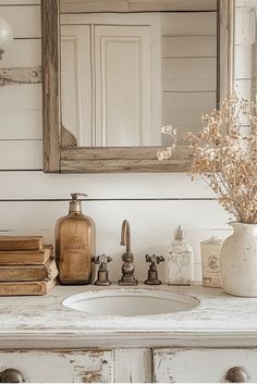 a bathroom sink sitting under a mirror next to a white counter top with books on it