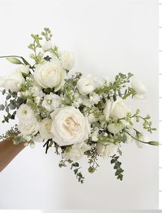 a bouquet of white flowers in someone's hand