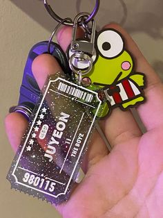 a person holding a keychain with a cartoon character on it