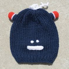 a knitted hat with ears and horns on the top is laying on the ground