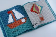 an open crocheted book with a sailboat and balloon on the front cover