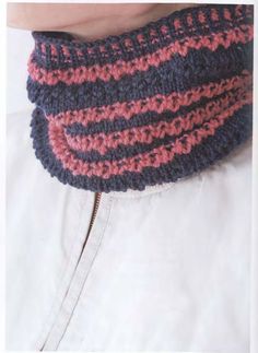 a close up of a person wearing a knitted cowl with pink and blue stripes