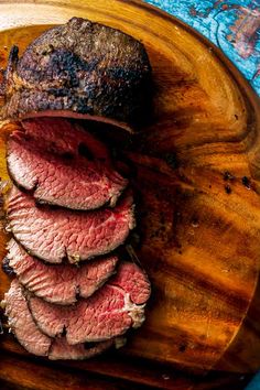 sliced meat on a wooden cutting board with blue background