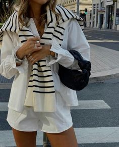 A elegant yet simple outfit. Some call it Old Money. White shorts and a white blouse with a striped sweater over the shoulders.  • Old money  • Elegant  • Summer  • Old money outfit  • Old money outfit ideas  • Old money aesthetic   • Old money clothes  • Elegant outfit  • Elegant Aesthetic   • Elegant clothes  • Summer outfit  • Summer outfit ideas  • Summer aesthetic   • Summer clothes  • White outfit  • White clothes  • Blouse  • Shorts  • Sweater  • Clothes  • Clothing   • Wear  • Ootd  • Outfit  • Adrette Outfits, Looks Pinterest, Europe Outfits, Looks Street Style, Stockholm Fashion, Mode Inspo, 가을 패션, Looks Style