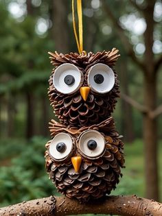 an owl made out of pine cones sitting on top of a tree branch