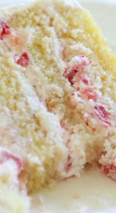 a close up of a piece of cake on a plate with strawberries and cream