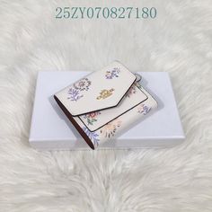 two wallets sitting on top of a white box next to a furnishing