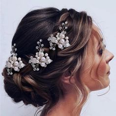 a woman wearing a bridal hair comb with flowers and pearls on it's head