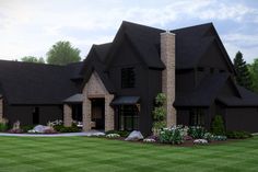 a large black house with lots of windows on the front and side of it is surrounded by green grass