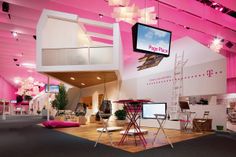 a room with pink walls and flooring that has various types of furniture on display