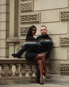 a man and woman sitting on a bench in front of a building