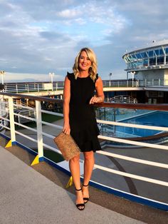 a woman standing on the deck of a cruise ship with her hand in her purse