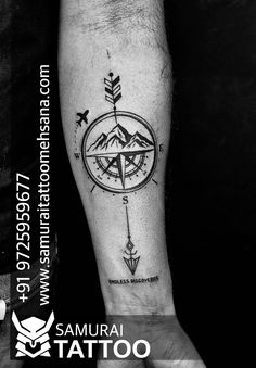 a man's arm with an arrow and compass tattoo on the left inner forearm