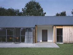 a house that is made out of wood and metal with glass doors on the outside