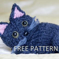 a knitted cat laying down on top of a bed with the words free pattern below it