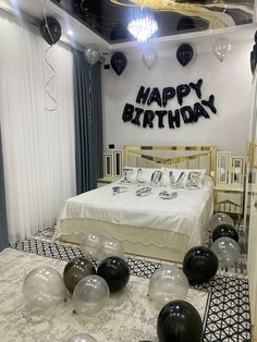 a bedroom decorated for a birthday with black and white balloons