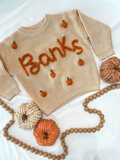 It's pumpkin season, y'all!  A customized name sweater is the perfect way to announce your new baby and welcome them to the world. They also make great gifts that add a personal touch. Sweaters can also be saved and remembered as a keepsake when your little one outgrows it.  Each sweater is hand-embroidered and uniquely made - no two sweaters are the same! Customize colors to create a one-of-a-kind sweater for your little one.  SWEATER IN PICTURE:  "Beige" 12-18m sweater "Pumpkin" yarn - - - - - Pumpkin Knit Sweater, Pumpkin Embroidery Sweater, Customizable Cotton Sweater For Fall, Customizable Cotton Fall Sweater, Embroidered Sweaters, Bride Cup, Name Sweater, Thanksgiving Sweater, Sweater Pumpkins