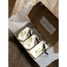 three soaps in a box on a wooden table