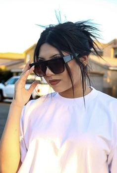 a woman with black hair and sunglasses talking on her cell phone