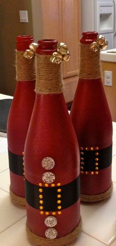 three red wine bottles with gold decorations on them