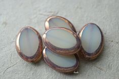 four pieces of glass sitting next to each other on a tablecloth covered floor with white and brown colors