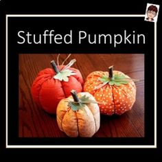 three small pumpkins sitting on top of a wooden table in front of a black frame