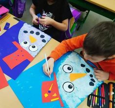 two children sitting at a table making paper snowmen with crayons on them