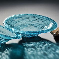 two blue glass bowls sitting on top of each other