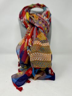 A stunning, large size,  lightweight scarf with tassels.   This soft scarf is created in a bright Aztec style pattern full of colours and geometric shapes. It can be worn in so many different ways, depending on your day and the occasion.  This Boho scarf scrunches up into a handful that easily fits in a handbag or coat pocket, and opens out again without a single crease. It offers a bright splash of sunny colours that makes it an eye-catching and contemporary item. DIMENSIONS: 180 cm x 90 cm rec Multicolor Fringe Scarf One Size, Multicolor Fringed Scarves One Size, Multicolor Fringe Scarves One Size, Bohemian Multicolor Shawl Scarves, Bohemian Multicolor Shawl Scarf, Multicolor Bohemian Silk Shawl, Bohemian Multicolor Dupatta One Size, Bohemian Multicolor Dupatta, One Size Multicolor Shawl Scarf