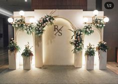 an archway decorated with flowers and greenery at the entrance to a wedding reception venue