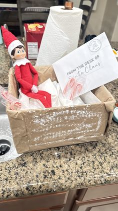 an elf is sitting in a box on the kitchen counter