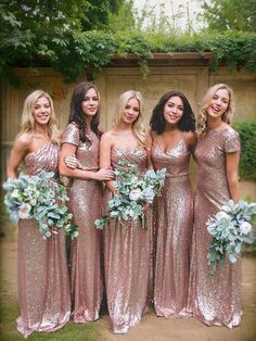 a group of women standing next to each other in long dresses with sequins on them