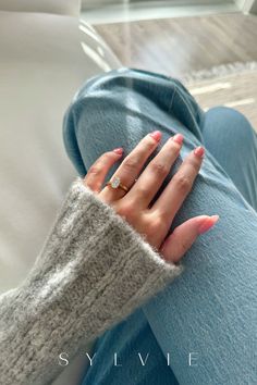 a woman's hand resting on her leg wearing a ring