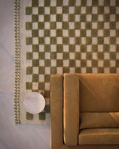 a brown couch sitting in front of a checkered wall